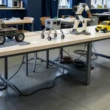 Robot cars and a robot arm on a lab bench