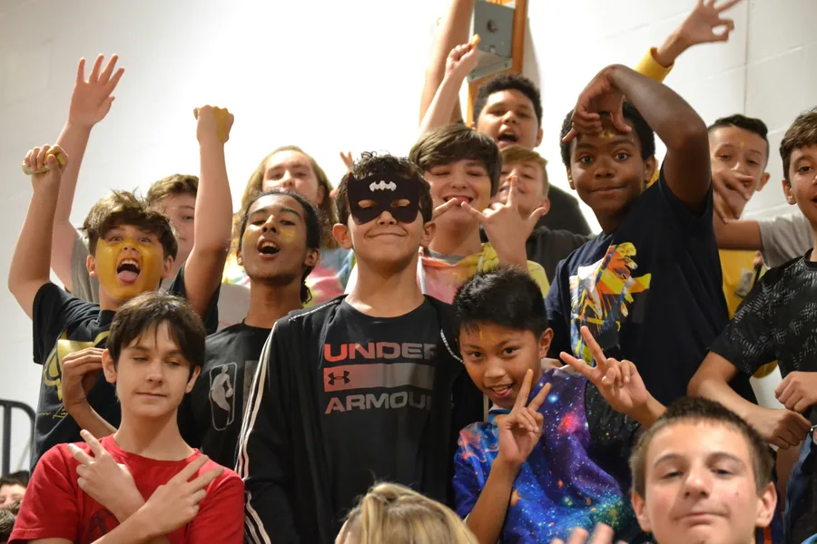 A crowd of cheering campers making peace signs