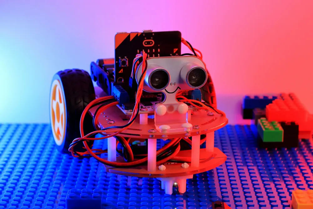 Small wheeled robot with wires and sensors on a building-brick base